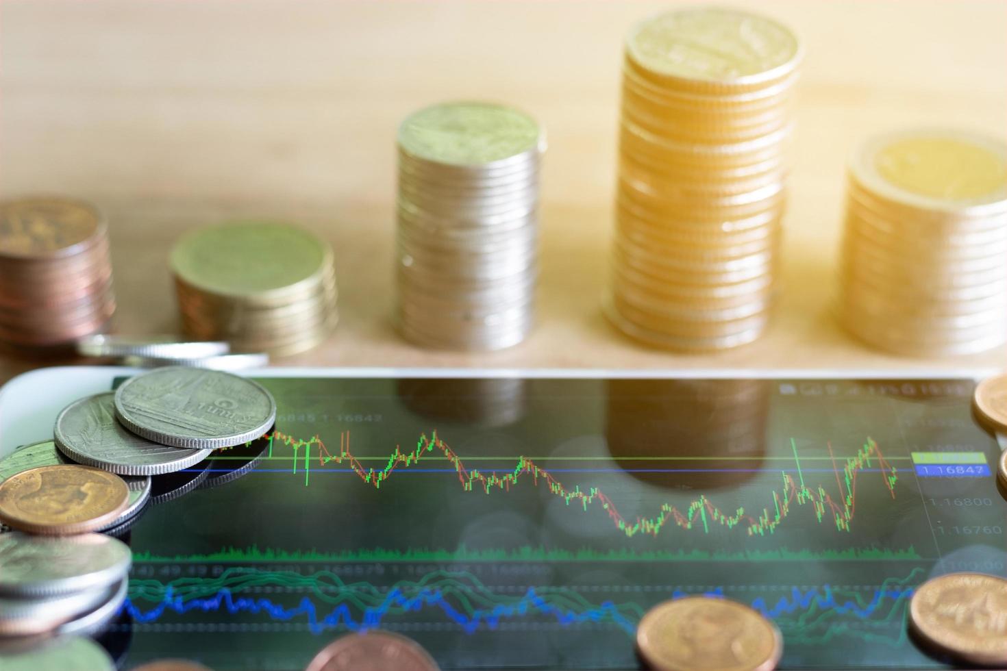 Smartphone display forex chart with coin stack. photo