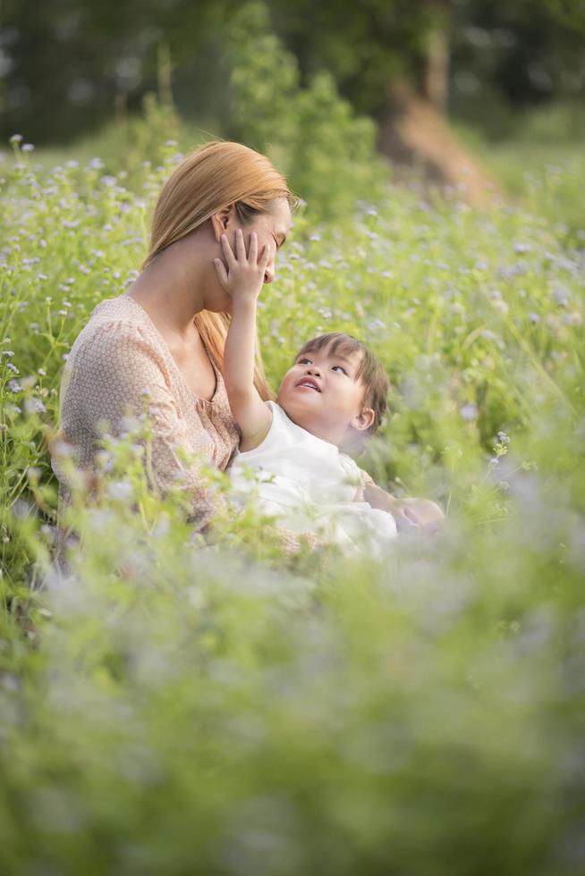 Mother and little daughter playing together in a meadow photo