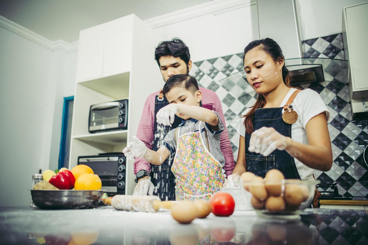 Happy family enjoying their time cooking together in the kitchen photo