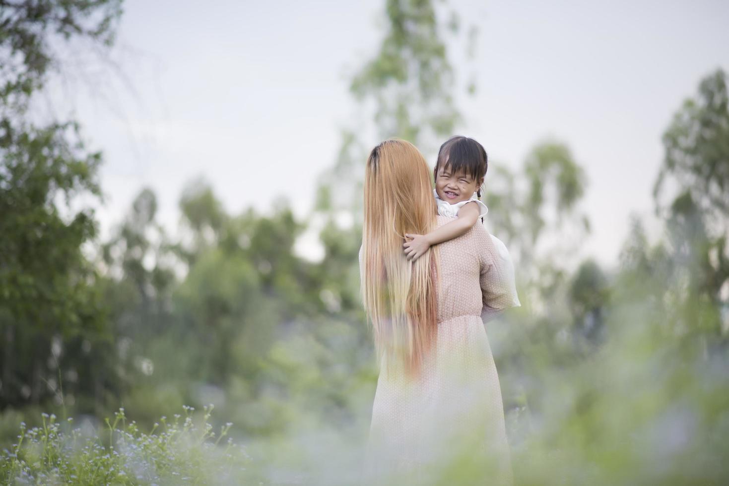 madre e hija jugando juntos en un prado foto