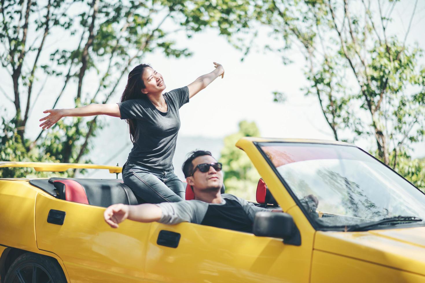 feliz pareja disfrutando de la capota abajo en convertible foto