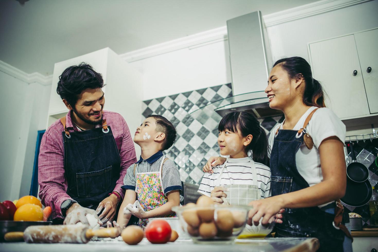 Happy family enjoying their time cooking together in the kitchen photo