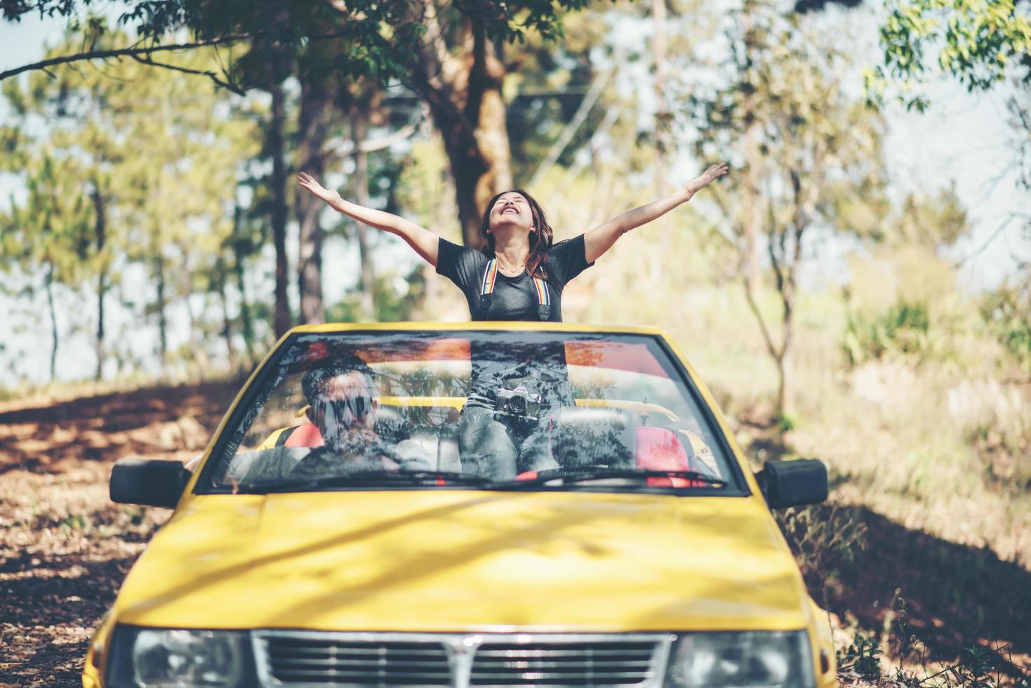 feliz pareja disfrutando de la capota abajo en convertible foto