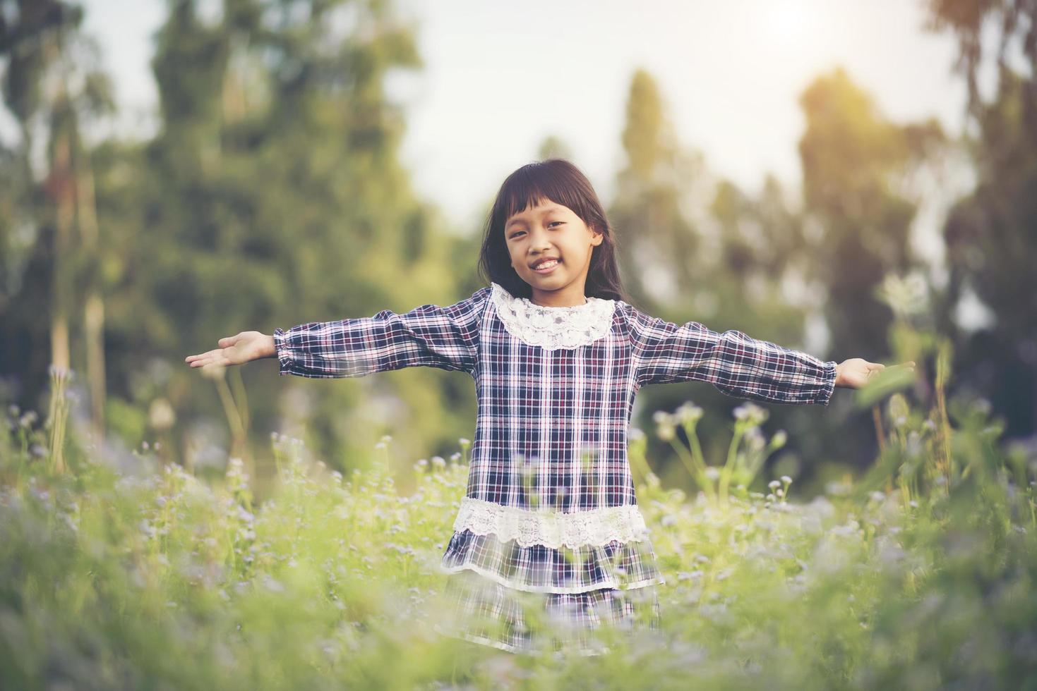 Little girl raising her hands in the fresh air photo