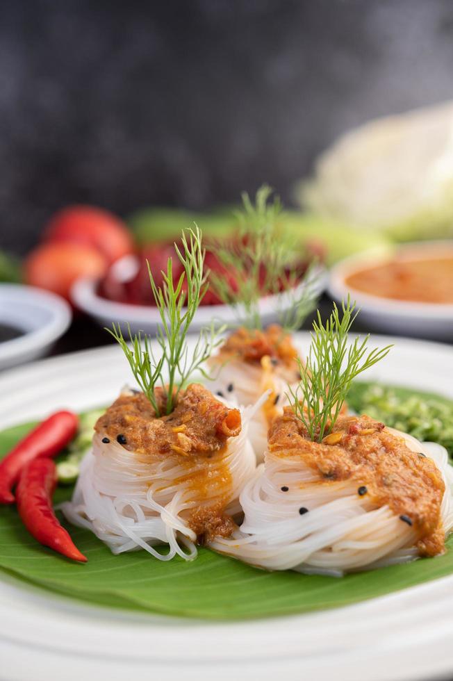 Rice noodle noodles topped with coconut milk and vegetables photo