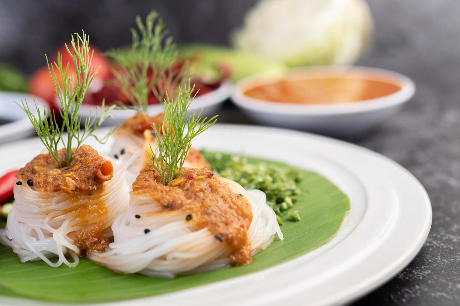 Rice noodle noodles topped with coconut milk and vegetables photo