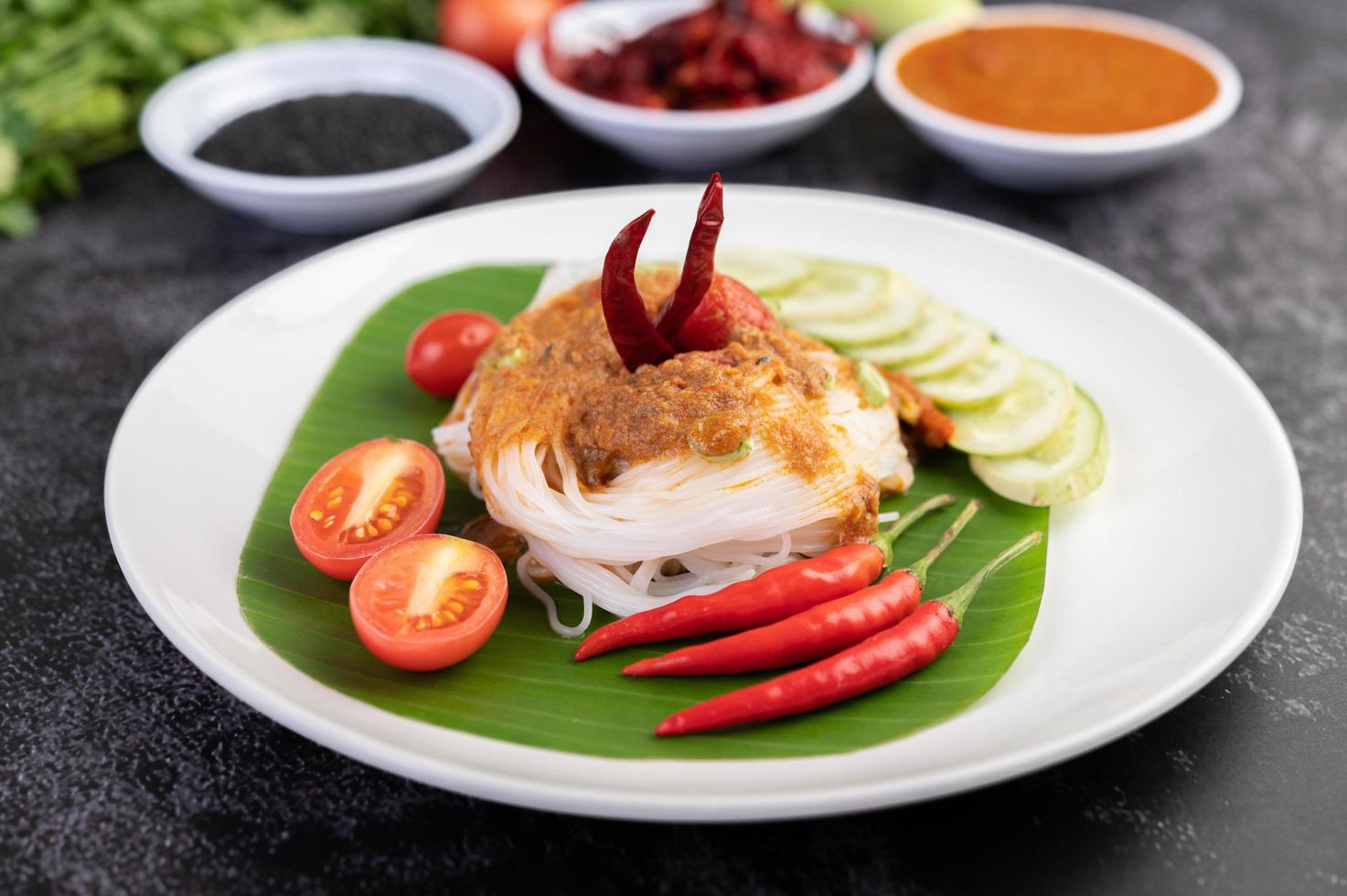 Rice noodle noodles topped with coconut milk and vegetables photo