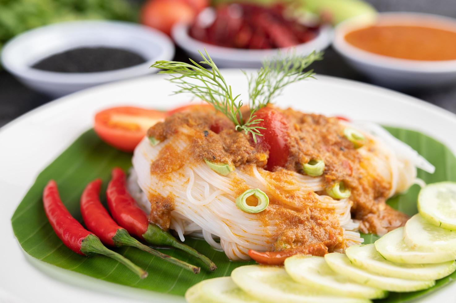 Rice noodle noodles topped with coconut milk and vegetables photo