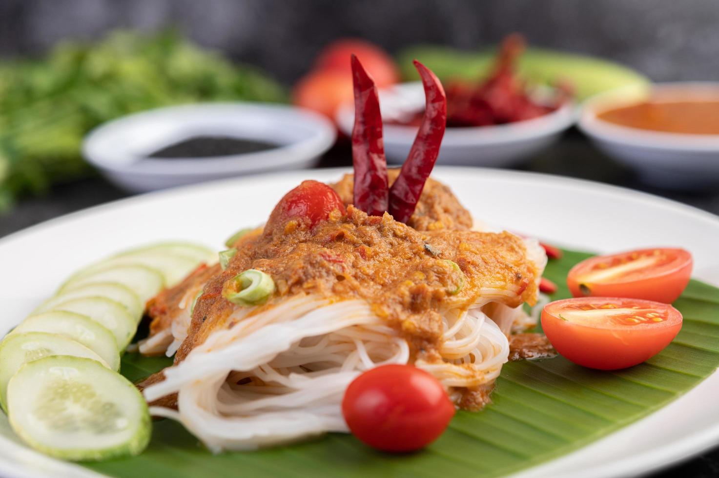 Rice noodle noodles topped with coconut milk and vegetables photo