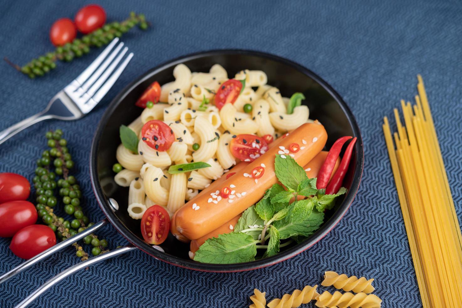 Fried macaroni and sausage in a frying pan photo