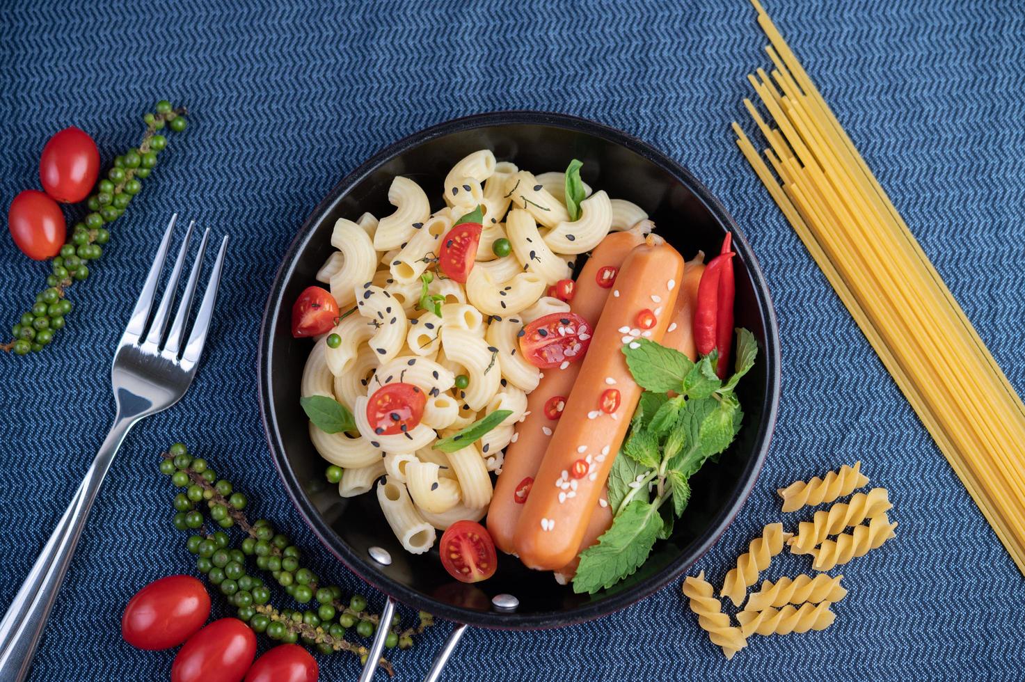 Fried macaroni and sausage in a frying pan photo