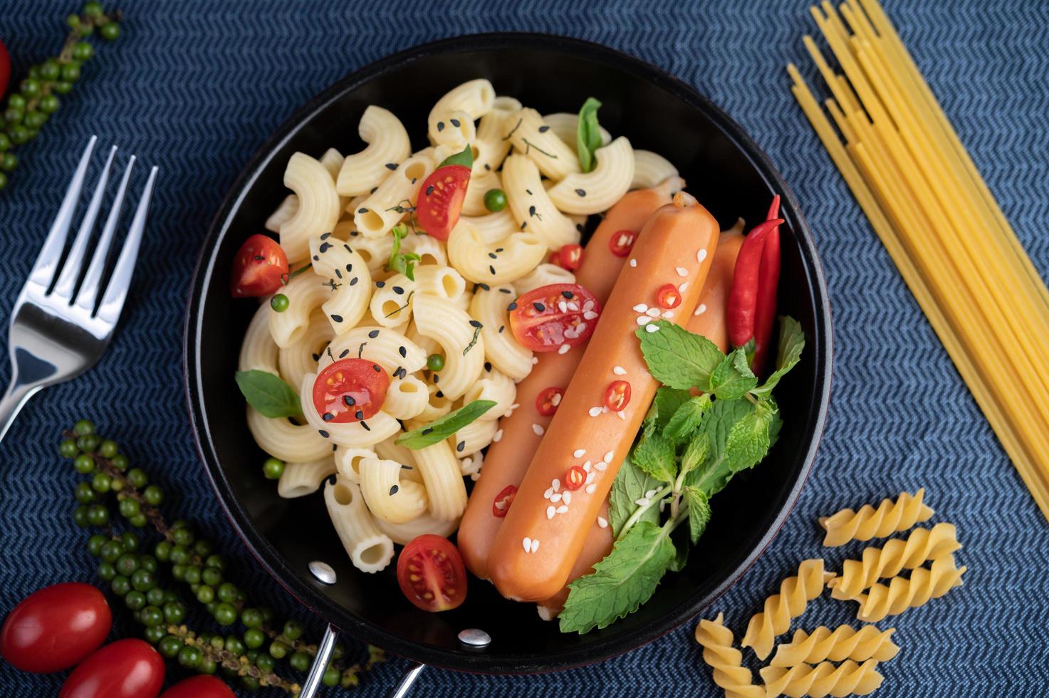 Fried macaroni and sausage in a frying pan photo