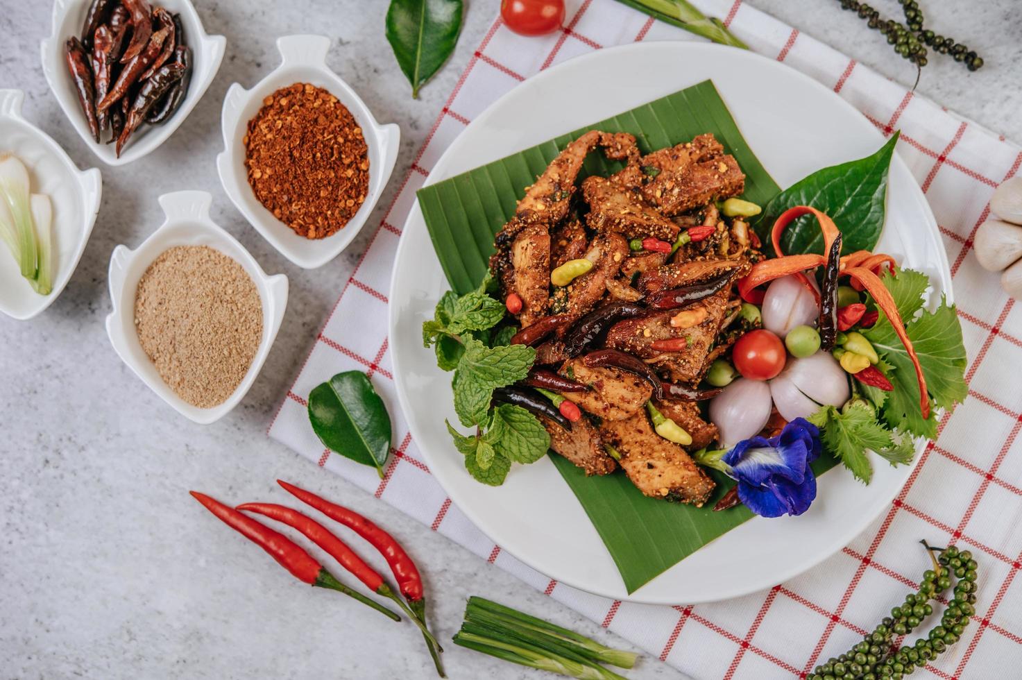 nam tok de cerdo con chile frito, tomate, lima, pepino y pimiento foto