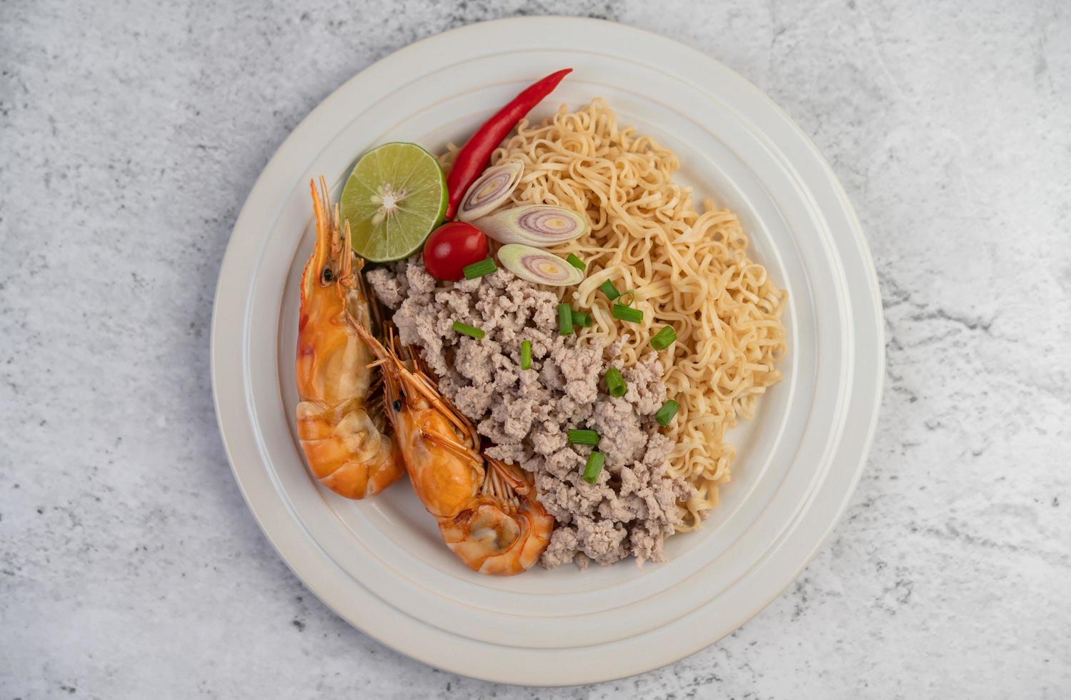 Noodles and shrimp on a white plate photo