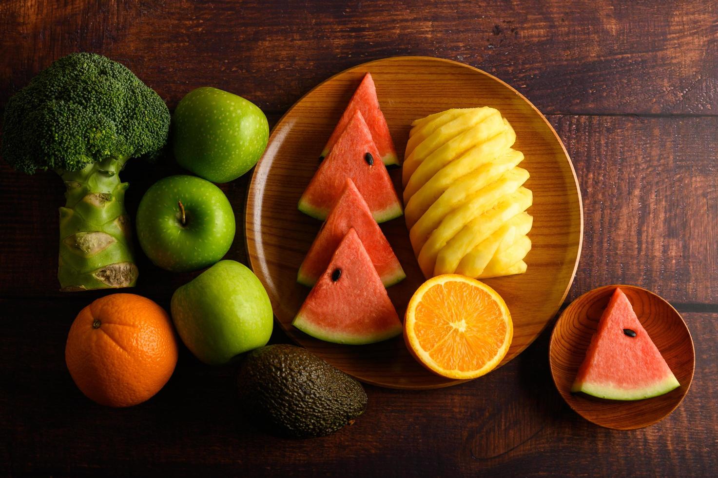 sandía de colores, piña, naranjas con aguacate y manzanas foto