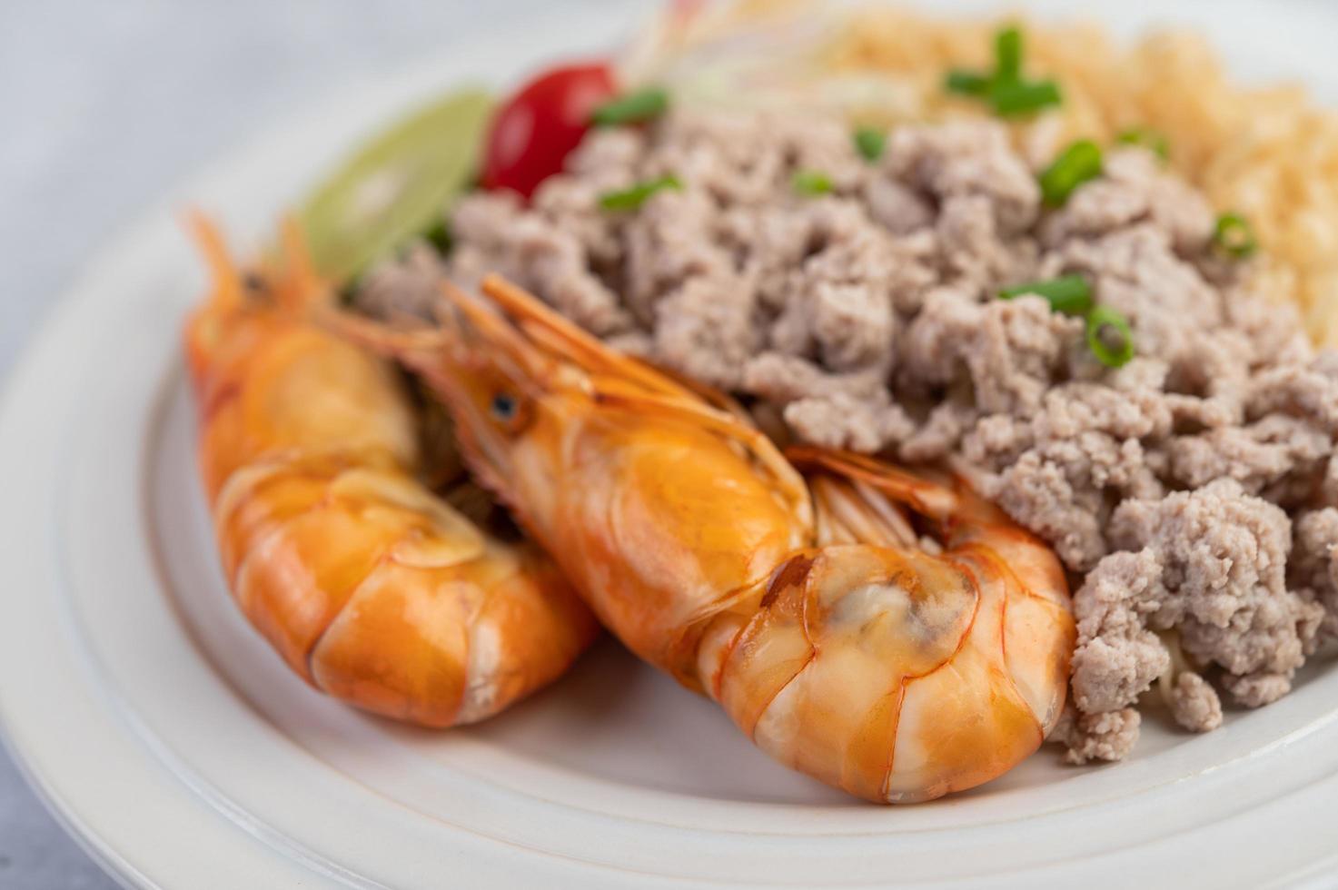 fideos y camarones en un plato blanco foto