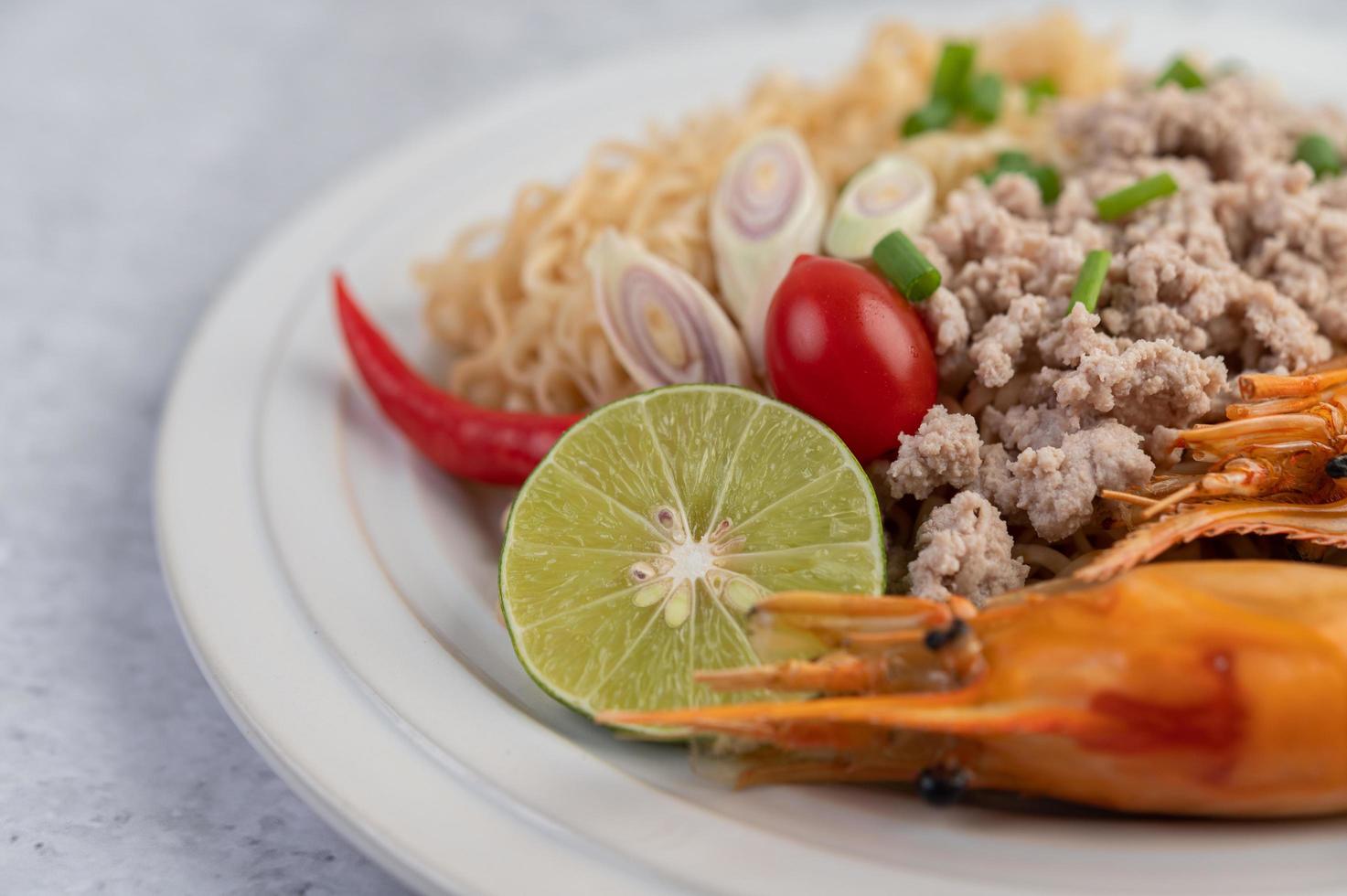 fideos y camarones en un plato blanco foto