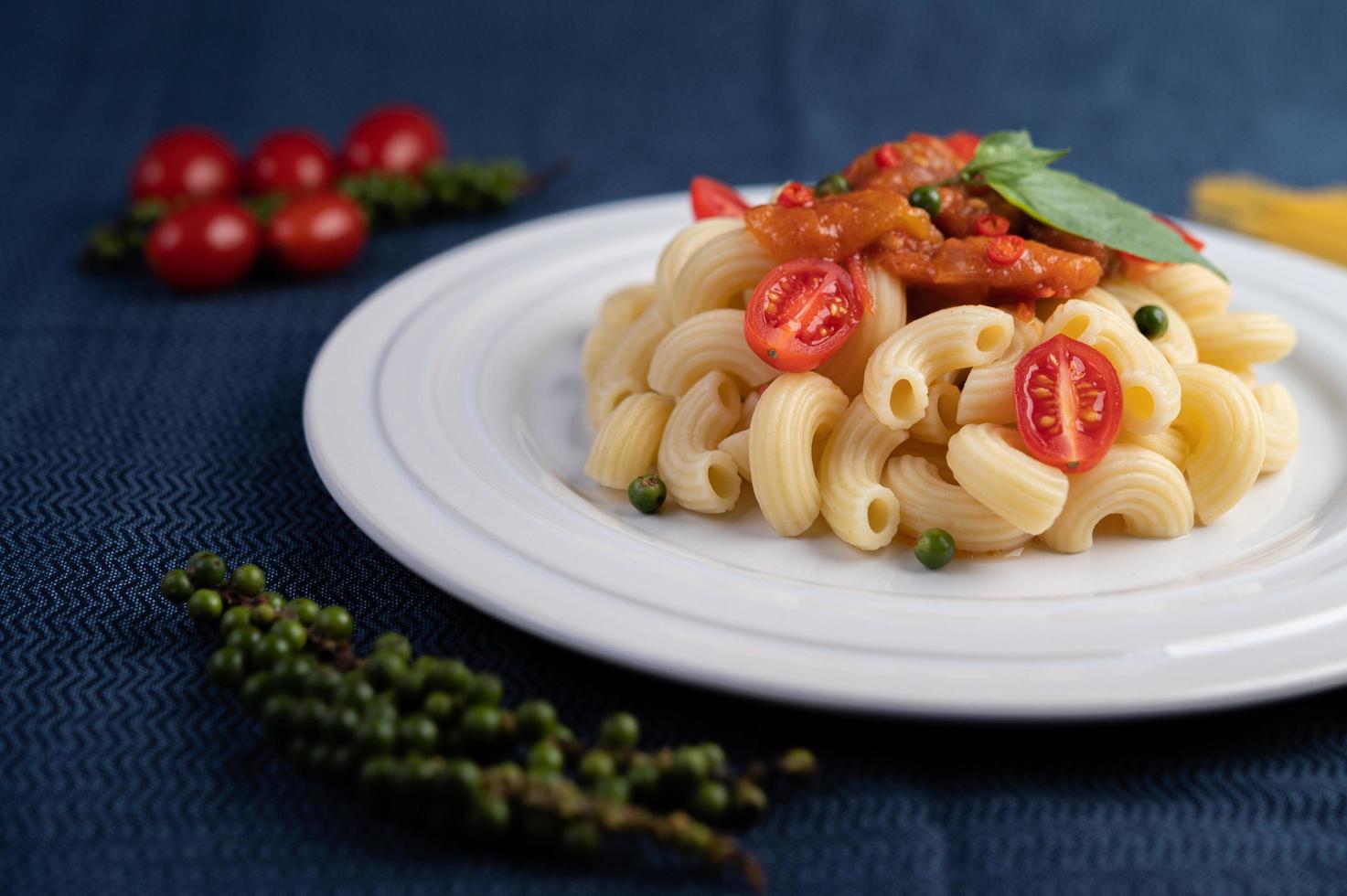 macarrones salteados con tomate, chile, semillas de pimiento y albahaca foto