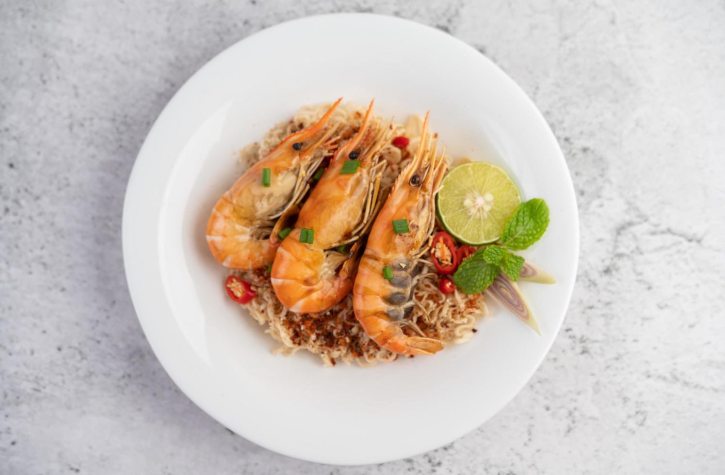 Noodles and shrimp on a white plate photo