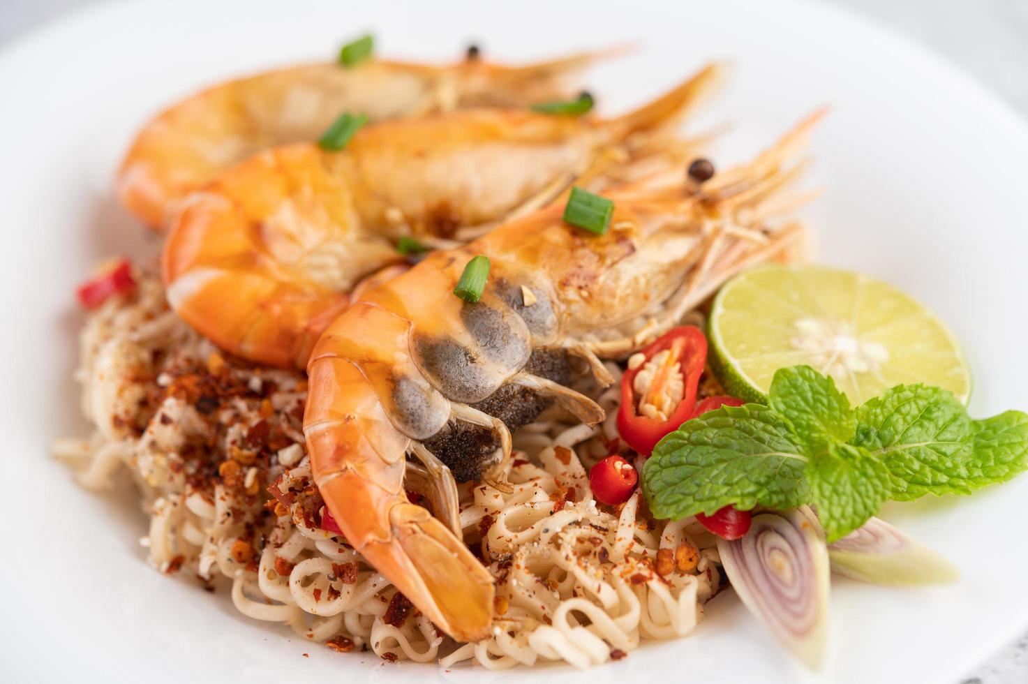 fideos y camarones en un plato blanco foto