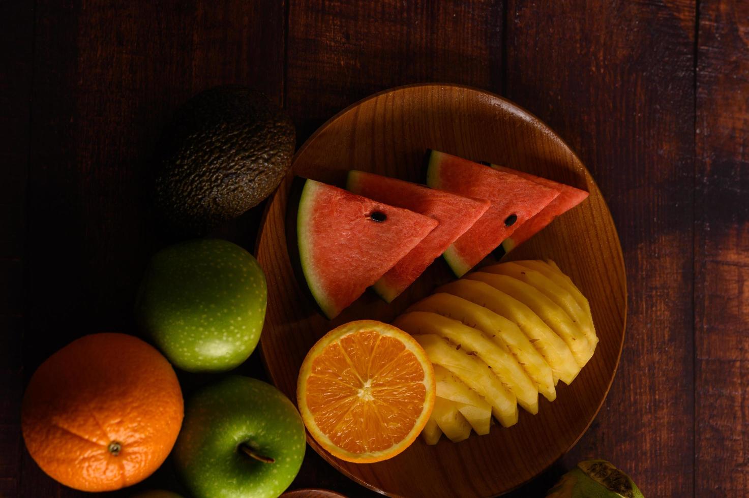 sandía de colores, piña, naranjas con aguacate y manzanas foto