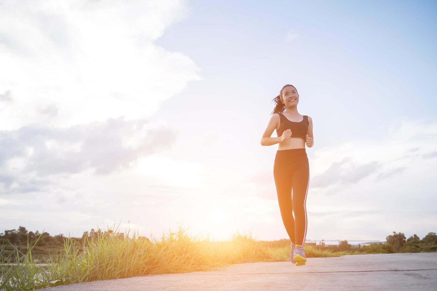 Una joven corredora feliz trotar al aire libre foto