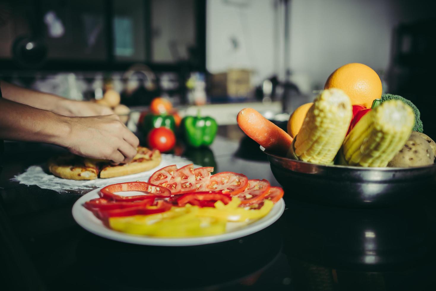 primer plano, de, un, mano, poniendo, coberturas, en, pizza casera foto