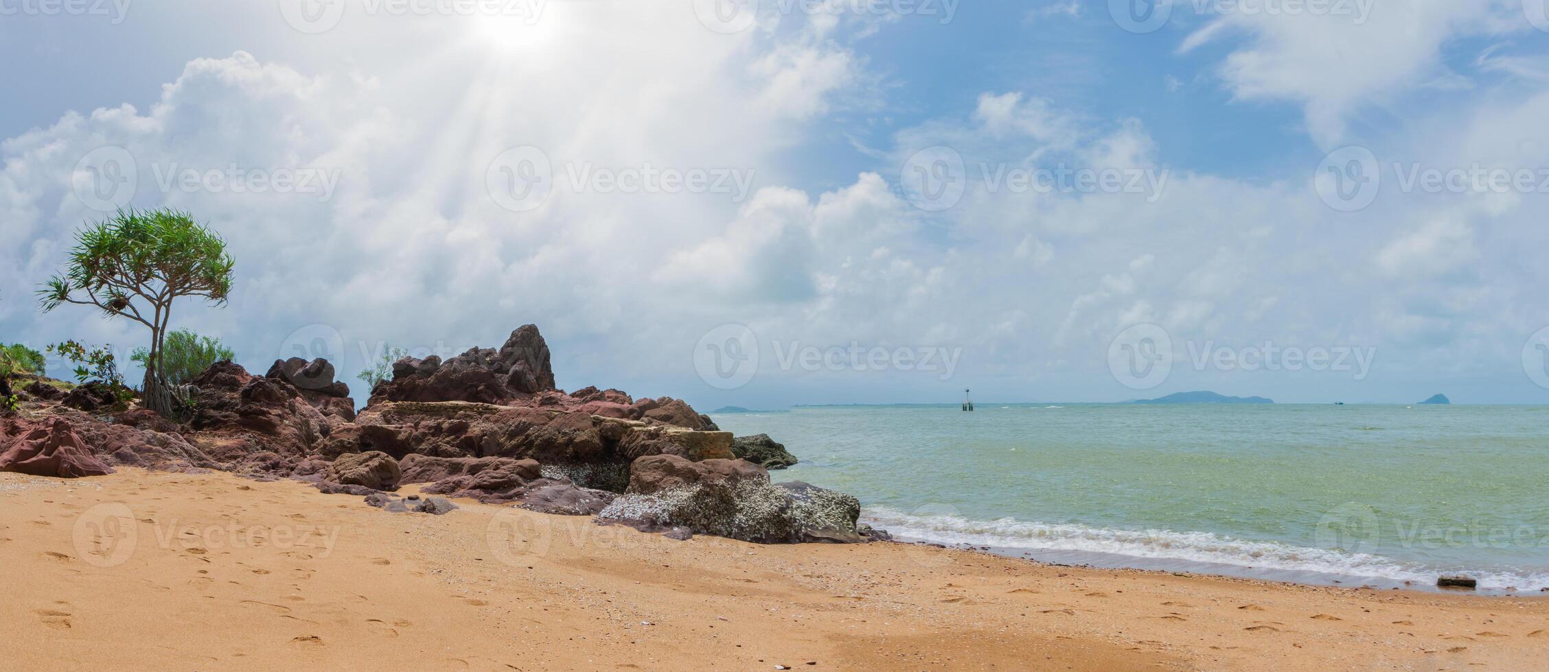 A sandy beach with rocks and water photo