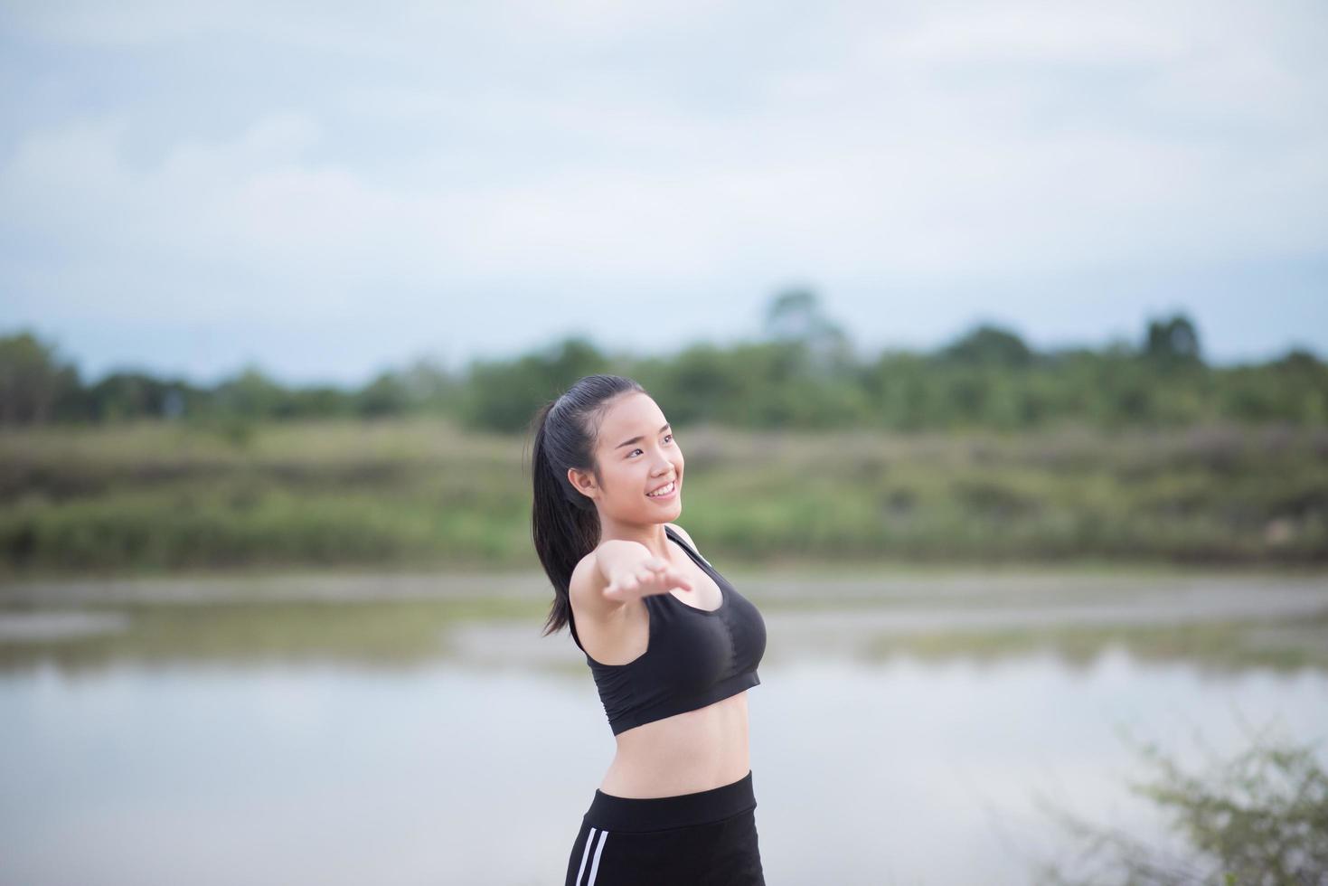 Mujer joven sana calentando al aire libre para entrenar foto