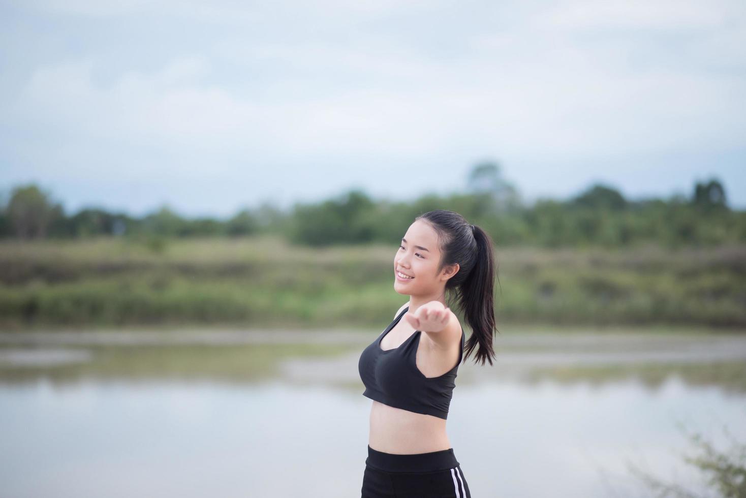 Mujer joven sana calentando al aire libre para entrenar foto