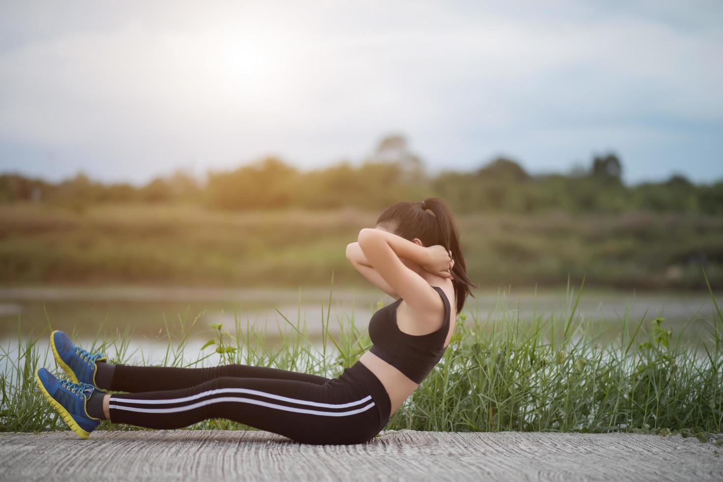 Healthy young woman warming up outdoors for training photo