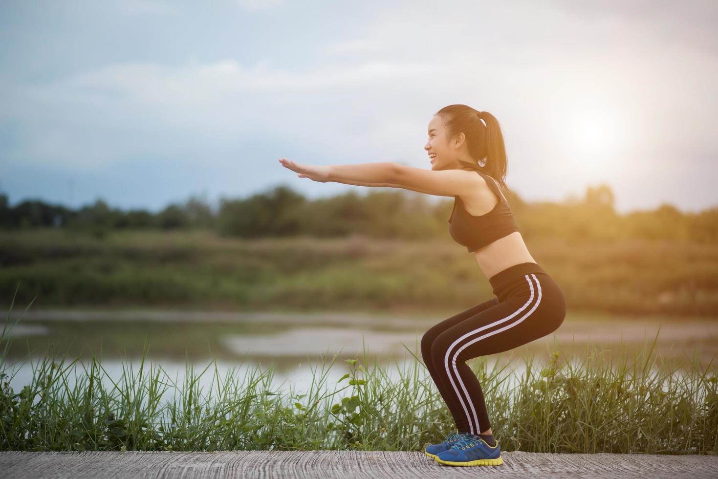 Healthy young woman warming up outdoors for training photo
