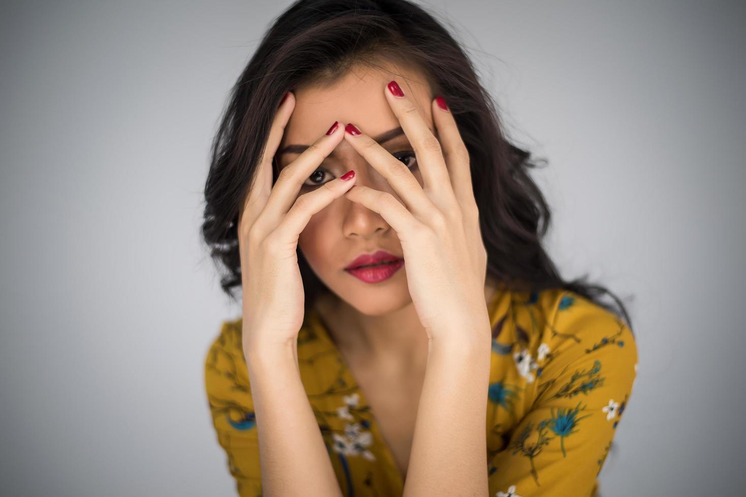 Beautiful young woman covers her face with hands photo