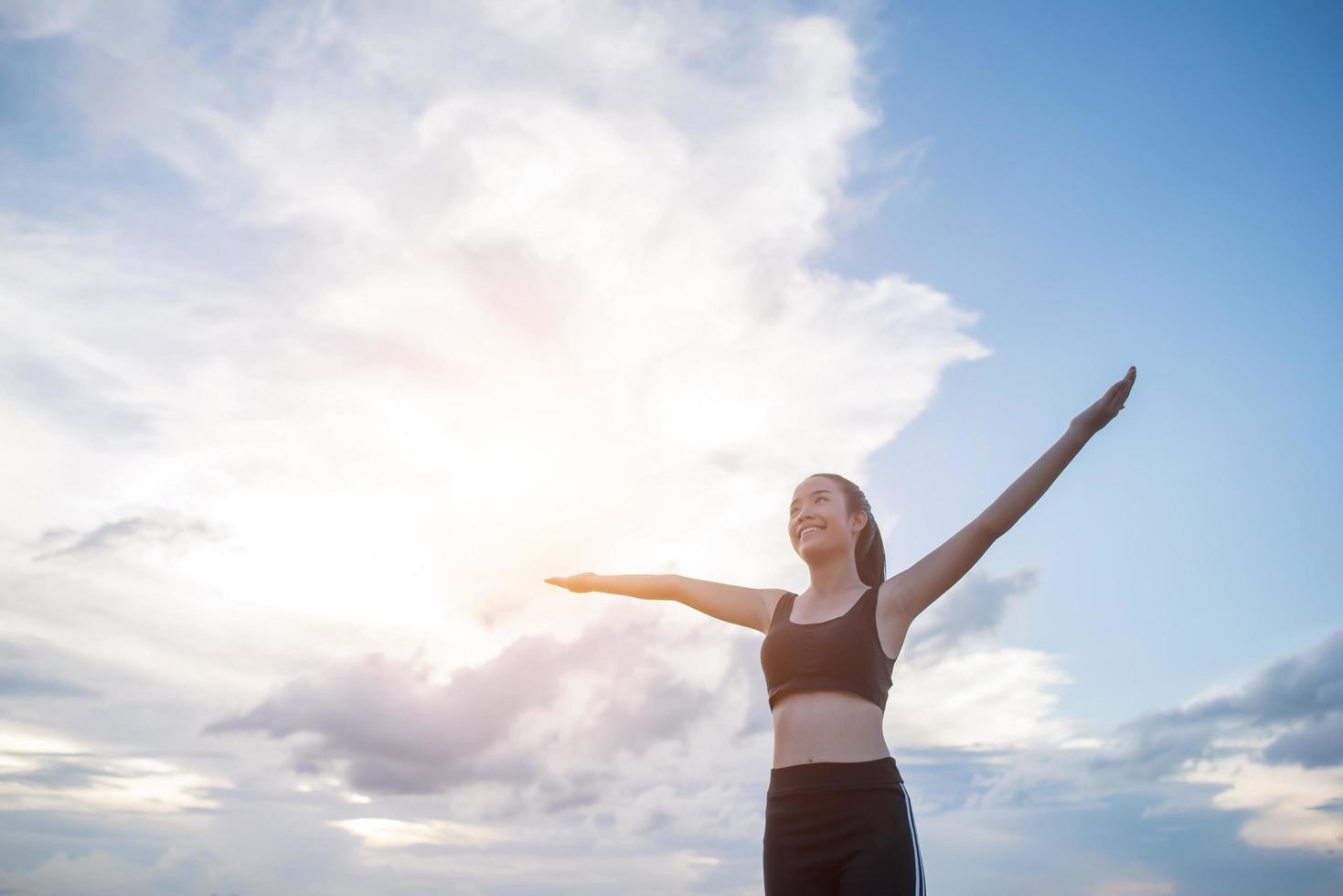 Happy smiling athletic teen with arms outstretched photo