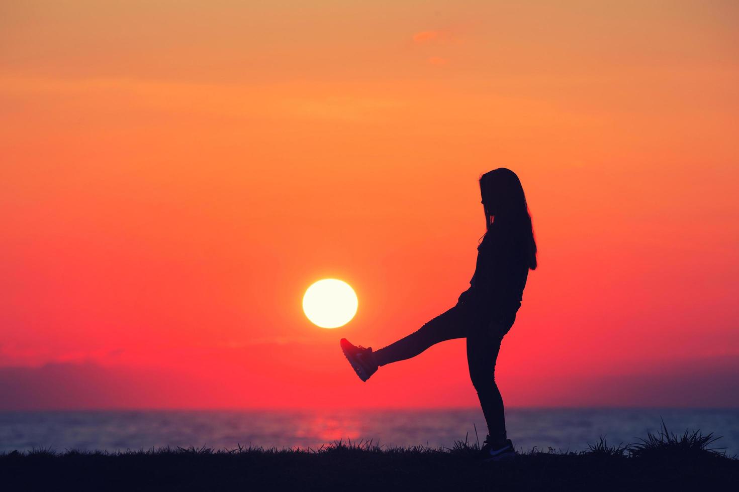 niña jugando en la puesta de sol foto
