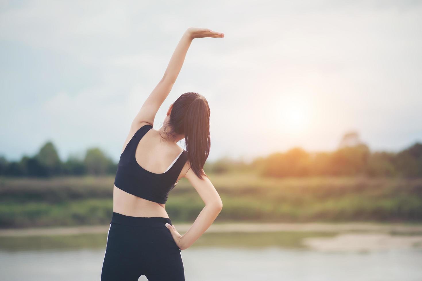 Healthy young woman warming up outdoors for training photo