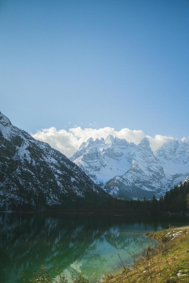 Mountain, lake, and trees with cloudy sky photo