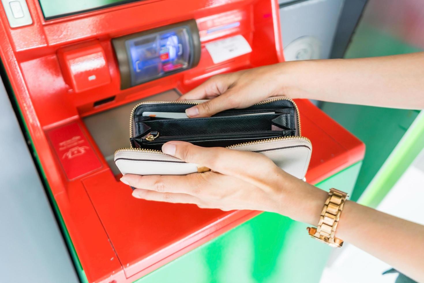 Close up of hand with wallet withdrawing cash at atm machine, finance, money, bank and people concept photo