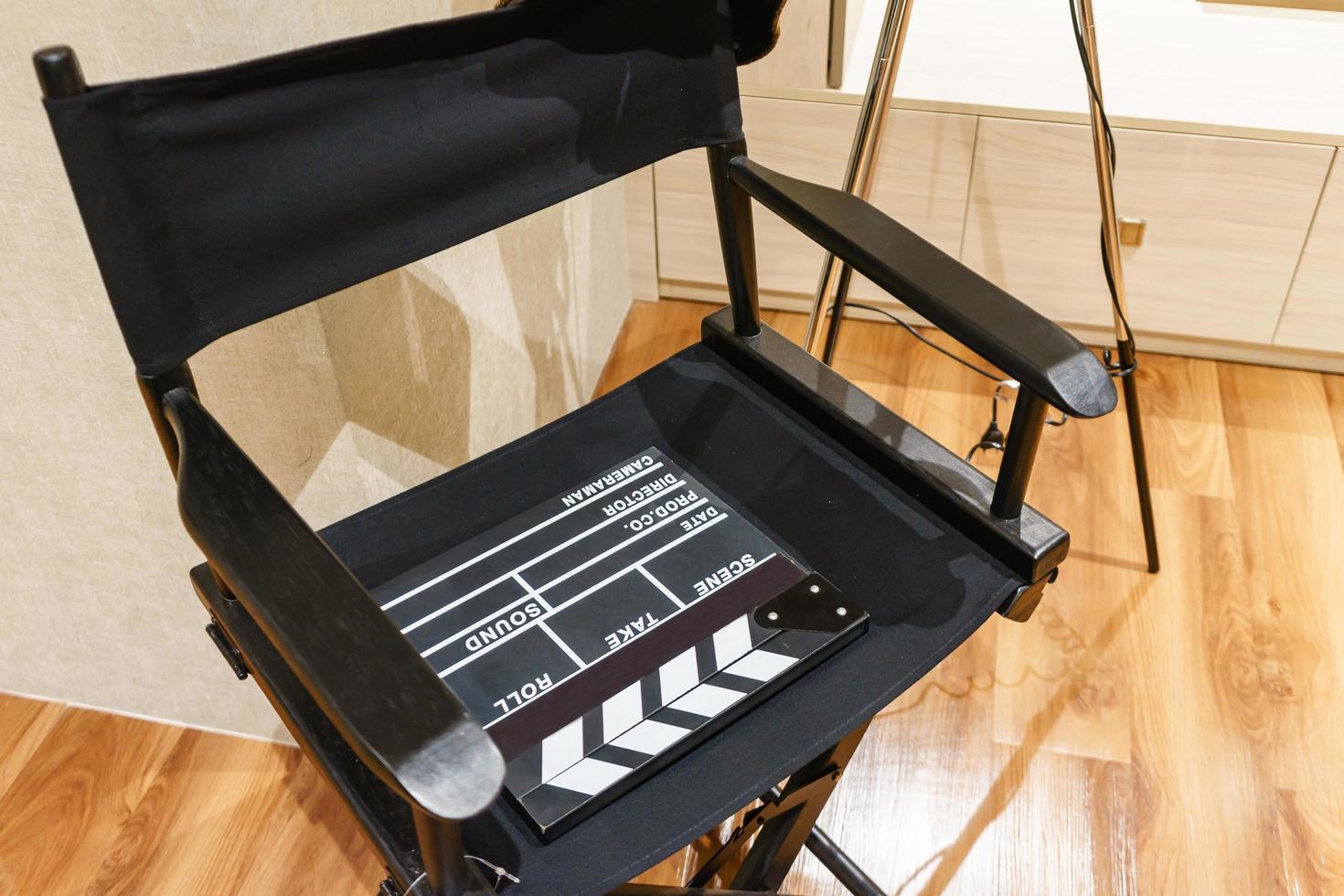 Director Chair, Movie Clapper and Megaphone in the volumetric light on wooden background. photo