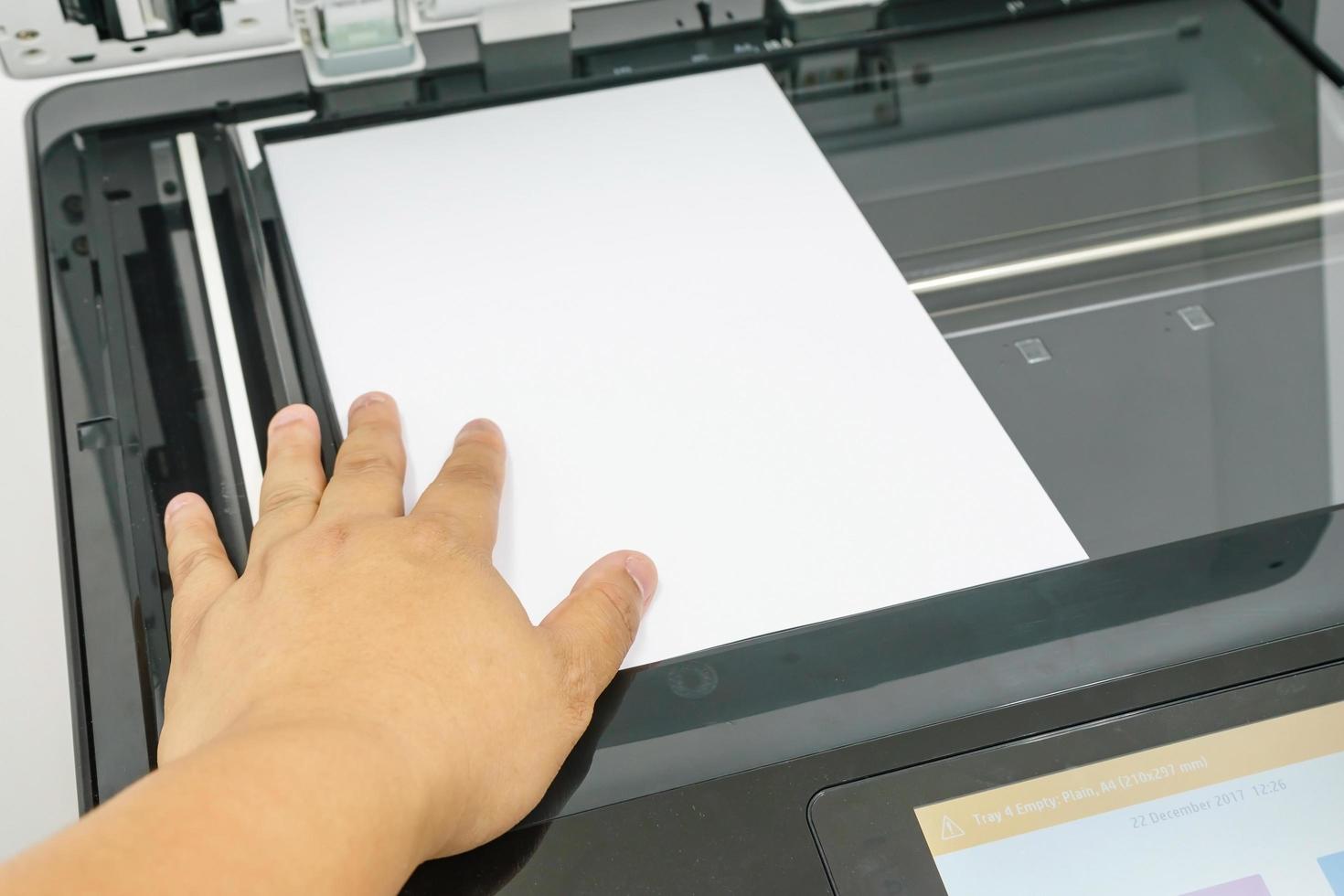 Close-up of young businessman hand operating printer in office photo