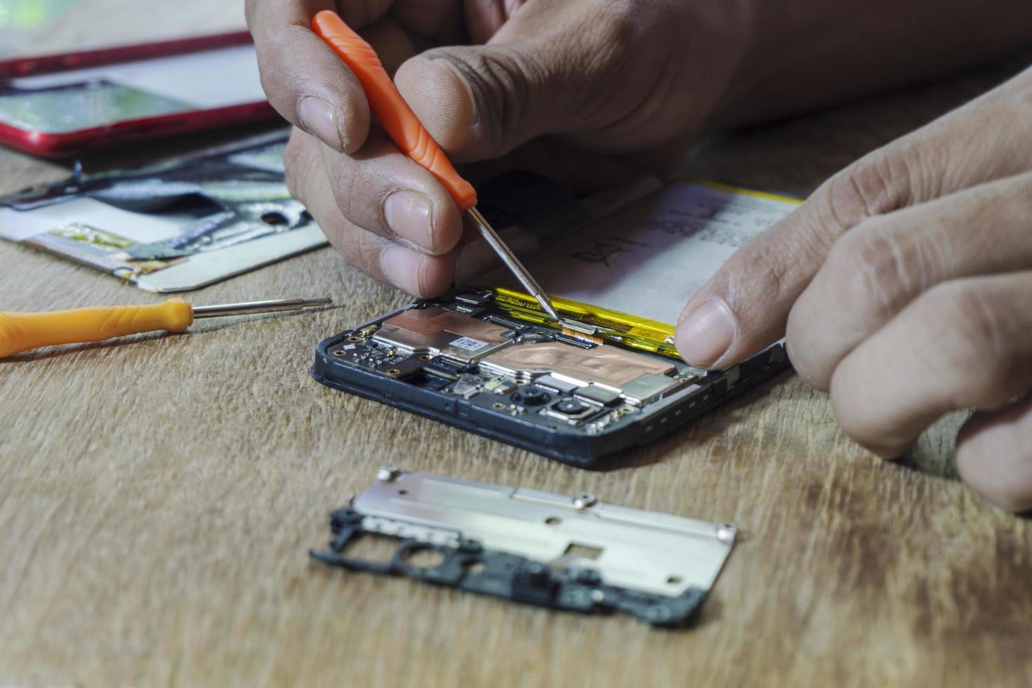 reparación de teléfonos inteligentes por un técnico profesional sobre una mesa. foto