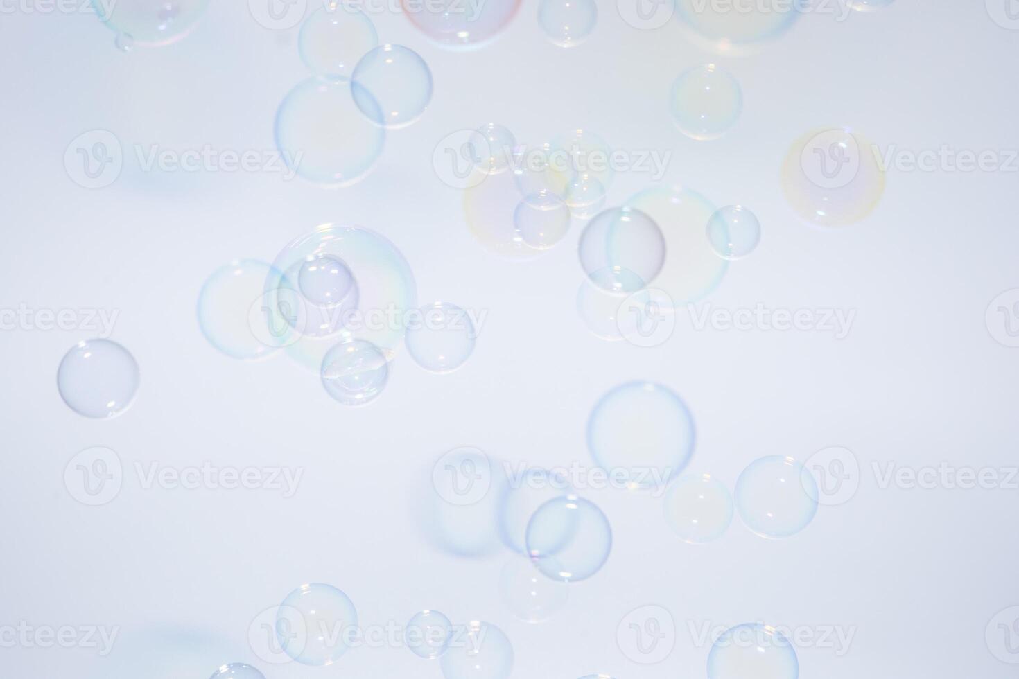 Soap bubbles floating in the air on a white background photo