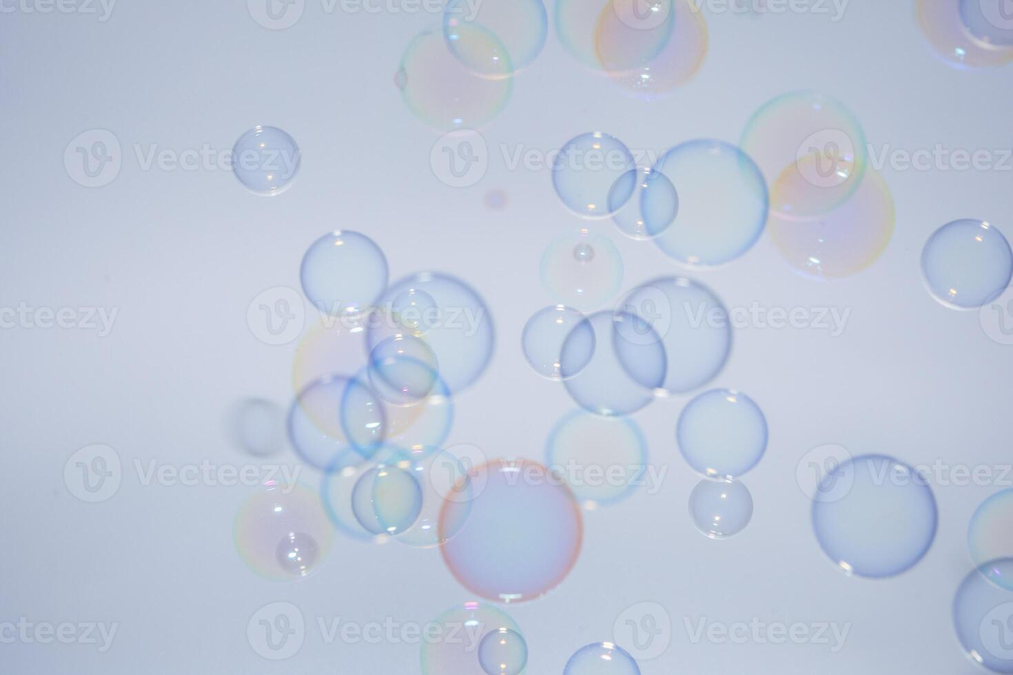 Soap bubbles floating in the air on a blue background photo