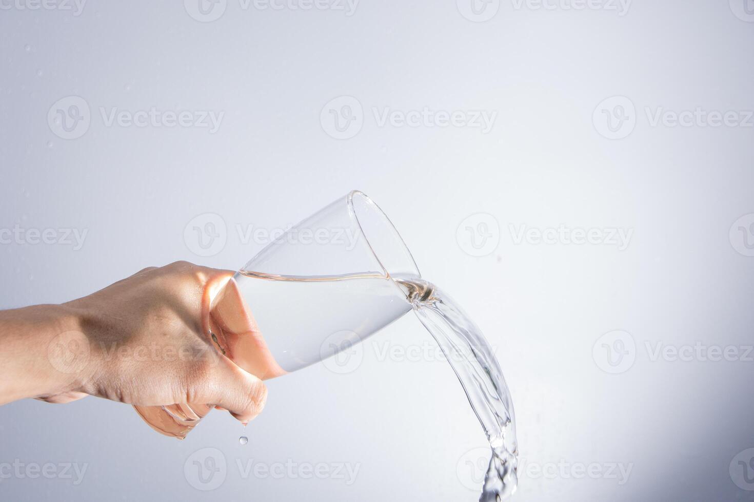 A hand holding a glass of water photo
