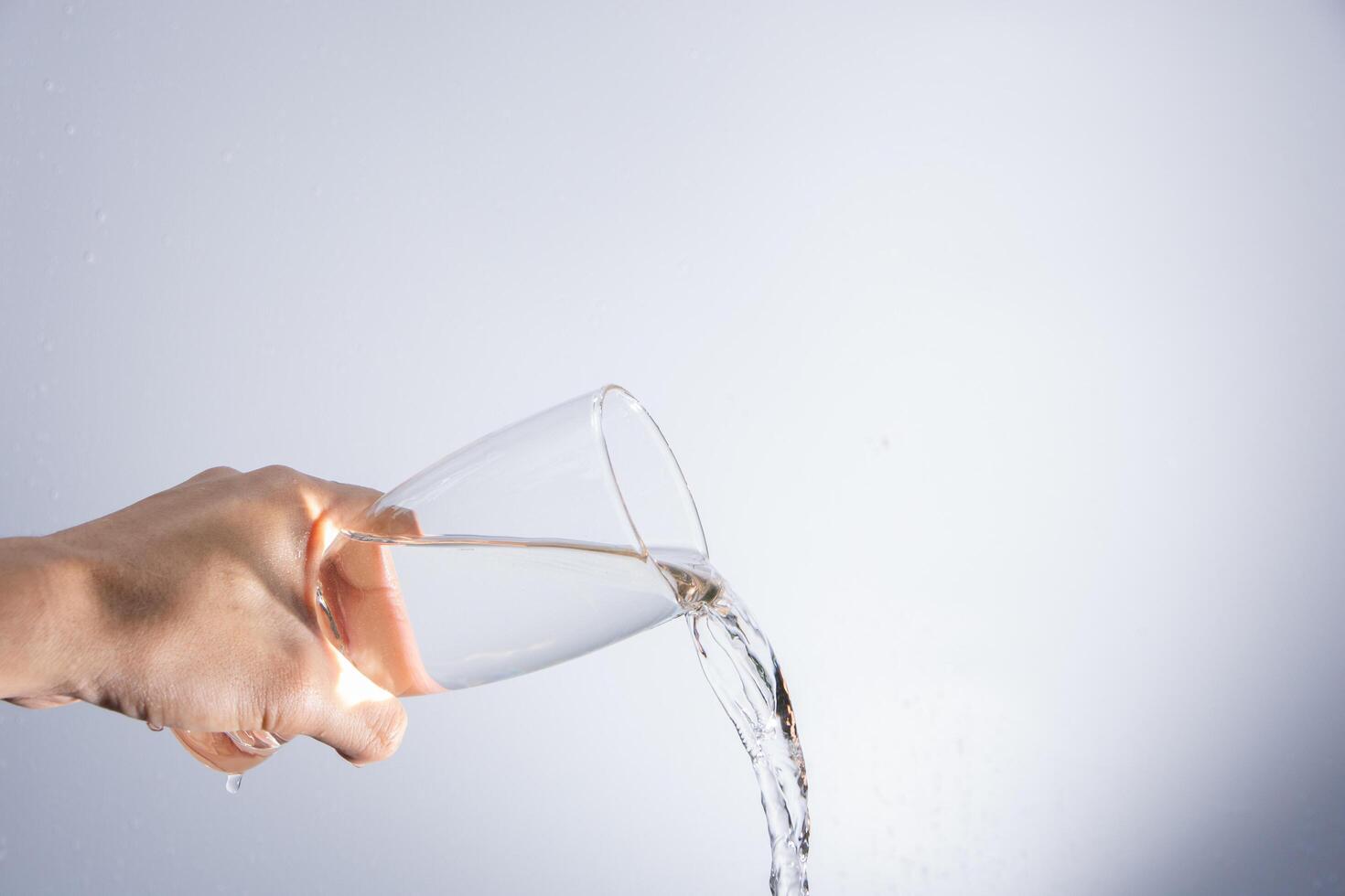 Pouring water out of the glass photo