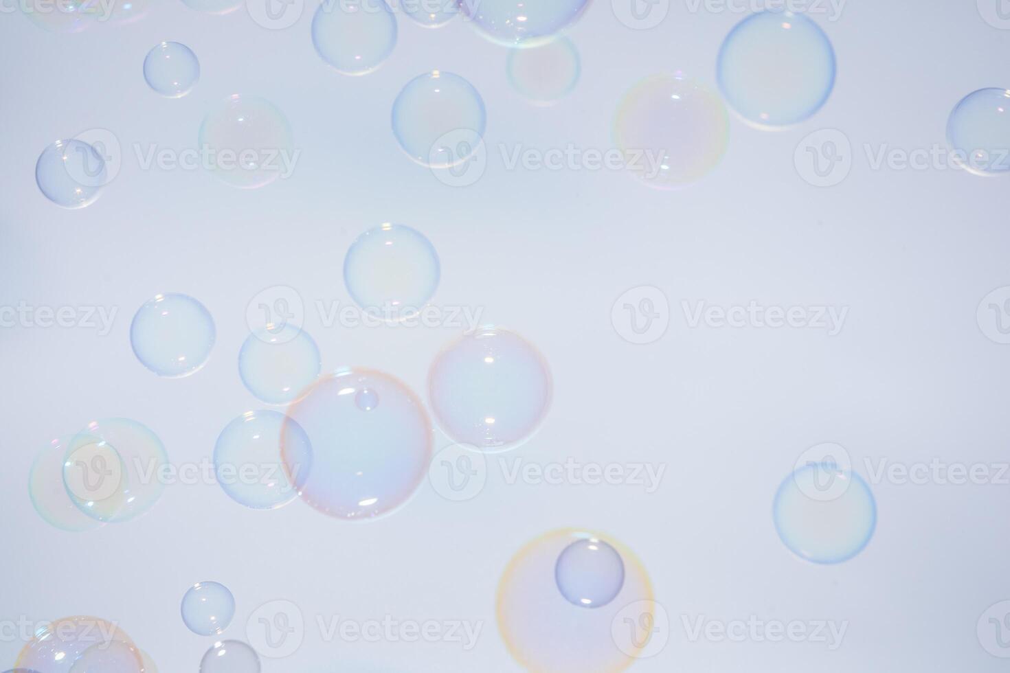 Soap bubbles floating in the air on a white background photo