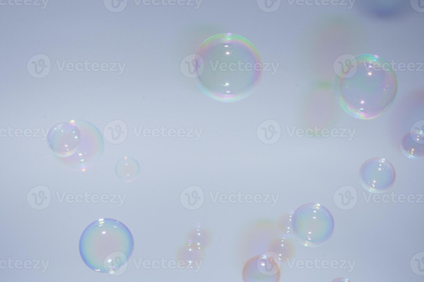 Soap bubbles floating in the air on a blue background photo