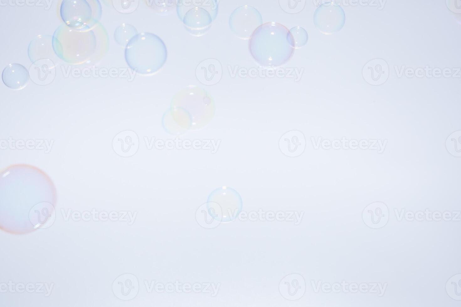 A man is standing in front of a blue background with soap bubbles photo