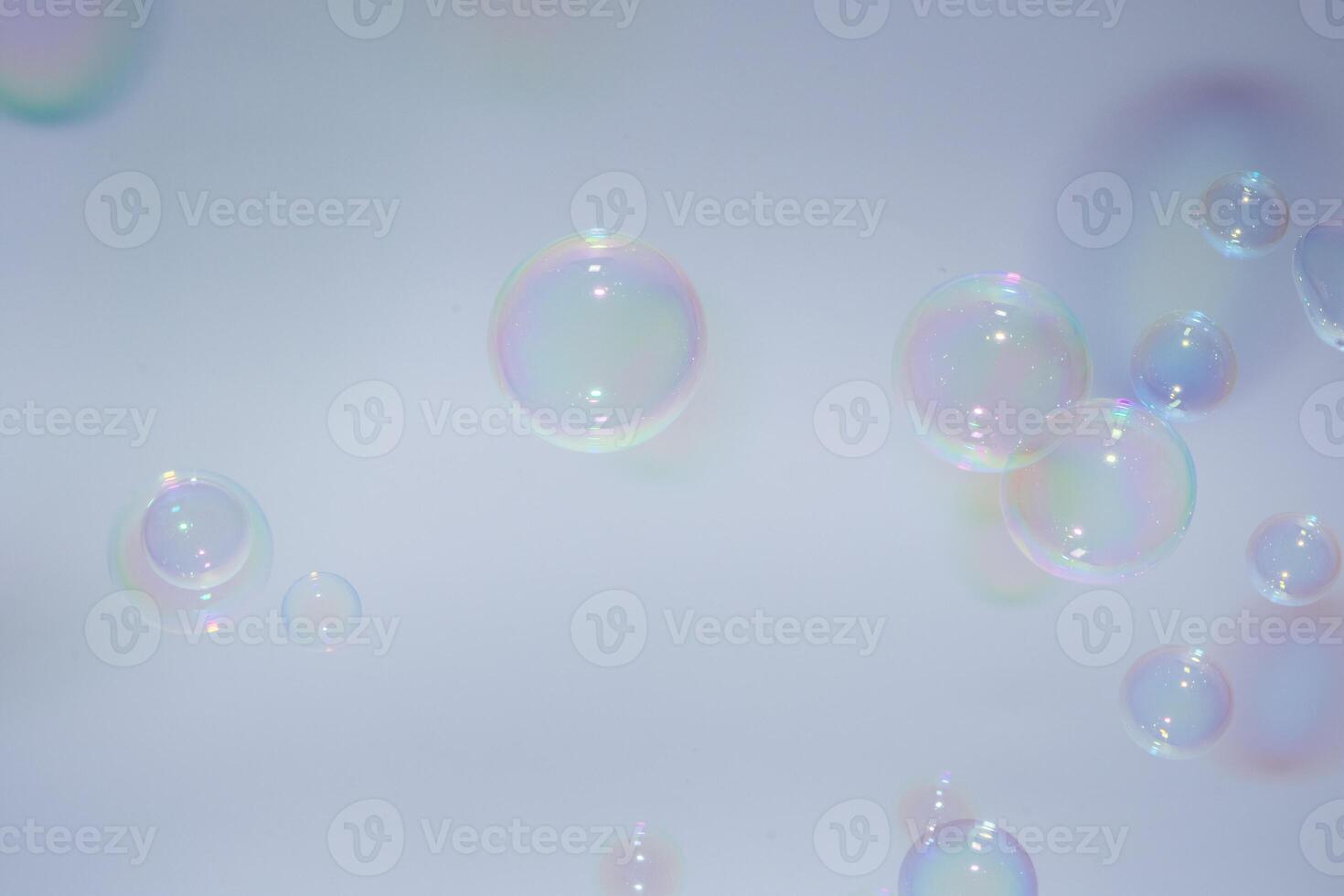 Soap bubbles floating in the air on a white background photo