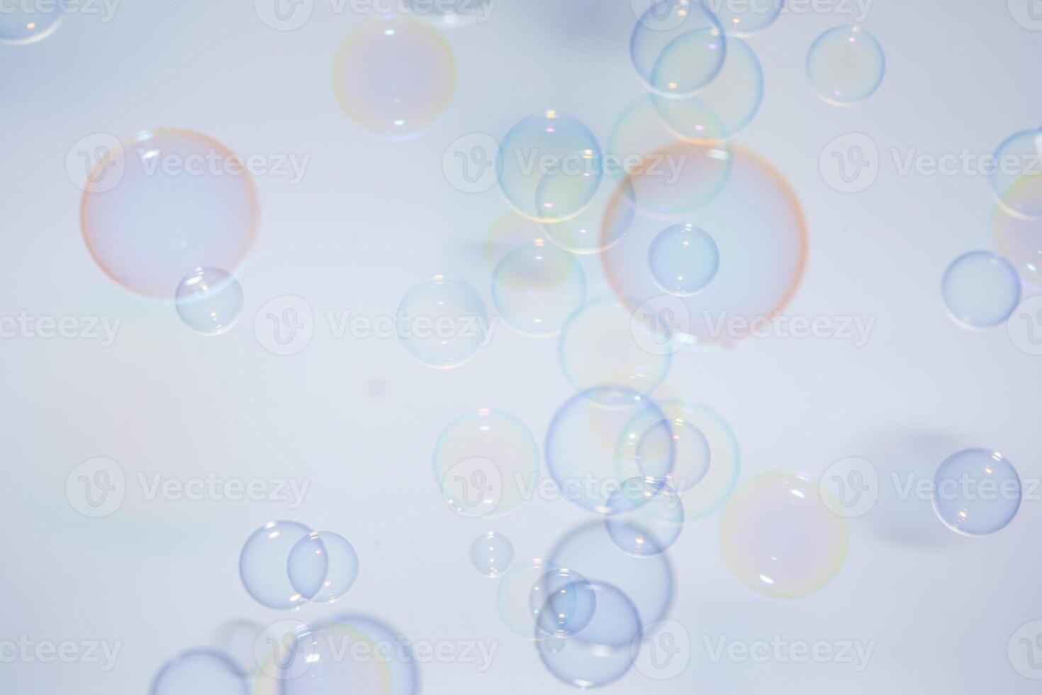 Soap bubbles floating in the air on a white background photo